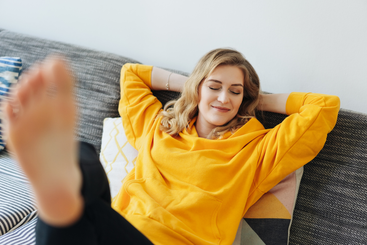 Barefoot young woman relaxing with her feet up